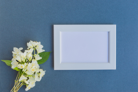 Mockup with a white frame and white jasmine flowers on a dark backgroundの写真素材