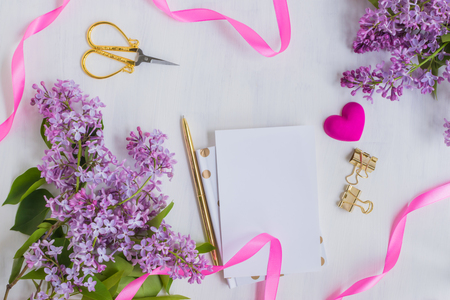 Flat lay desk with lilac branches and notebook on light backgroundの写真素材