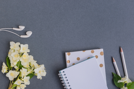 Flat lay desk with white jasmine flowers and notebook on dark backgroundの写真素材