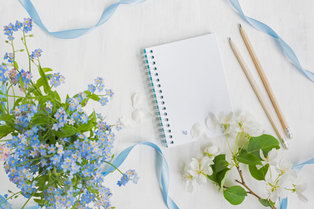 Mockup notebook with blue and white flowers and light backgroundの写真素材