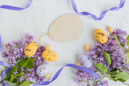 Easter eggs and lilac branches on a light backgroundの写真素材