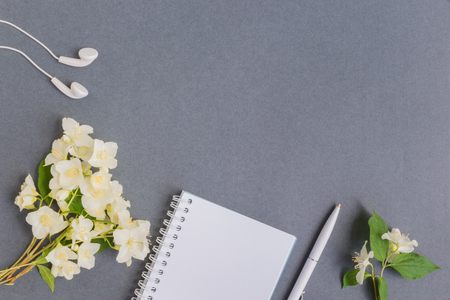 Flat lay desk with white jasmine flowers and notebook on dark backgroundの写真素材