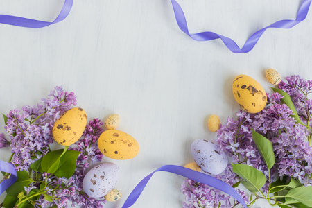 Easter eggs and lilac branches on a light backgroundの写真素材