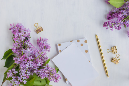 Flat lay desk with lilac branches and notebook on light backgroundの写真素材
