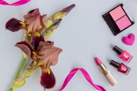 Flat lay desk with iris flower and cosmetic on light blue backgroundの写真素材