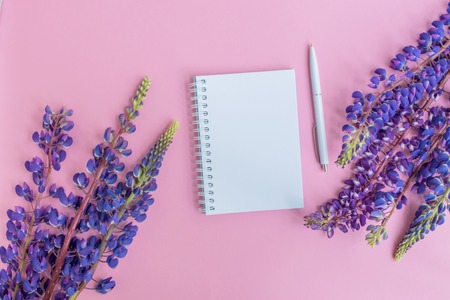 Mockup notebook with lupine flower on a pink background empty space for your text, top viewの写真素材