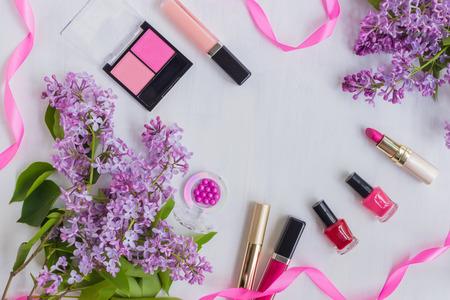 Flat lay desk with lilac branches and cosmetic on light backgroundの写真素材