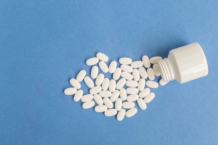 White pills on a blue background. Medical compositionの写真素材