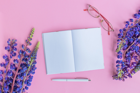 Mockup notebook with lupine flower on a pink background empty space for your text, top viewの写真素材