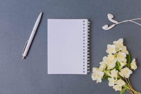 Mockup notebook with white jasmine flowers and dark background empty space for your text, top viewの写真素材