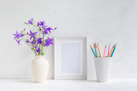 Home interior with decor elements. White frame, flowers in a vase, pencilsの写真素材