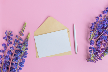 Mockup white greeting card and envelope with lupine flower on a pink backgroundの写真素材