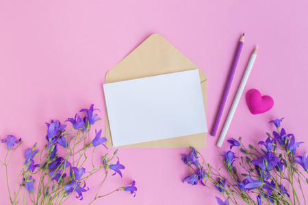 Mockup white greeting card and envelope with summer flowers and pink backgroundの写真素材