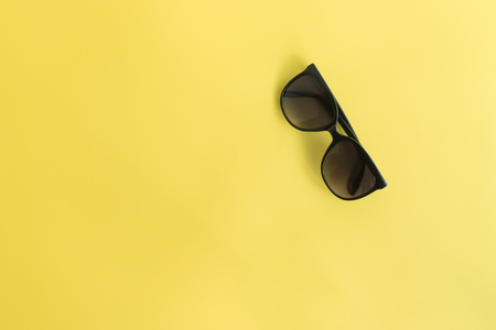 Sunglasses on a yellow background. Top view, flat layの写真素材