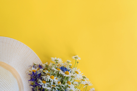 Summer hat and flowers on a yellow background. Top view, flat layの写真素材