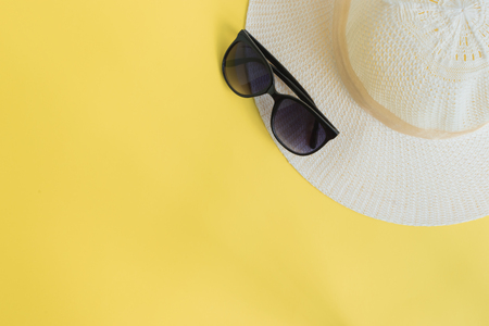 Summer hat and sunglasses on a yellow background. Top view, flat layの写真素材