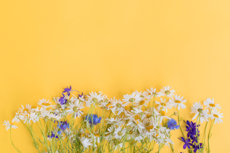 Bouquet of summer flowers on a yellow background. Top view, flat layの写真素材