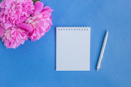 Mockup notebook with pink peonies on a blue backgroundの写真素材