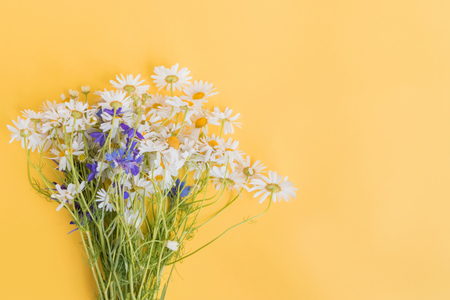 Bouquet of summer flowers on a yellow background. Top view, flat layの写真素材