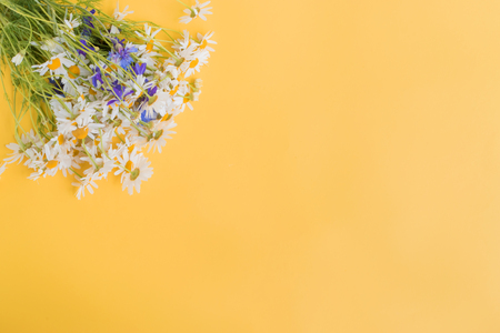Bouquet of summer flowers on a yellow background. Top view, flat layの写真素材