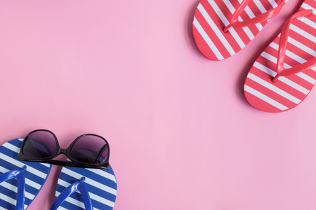 Flip flops and sunglasses on a pink background. Top view, flat layの写真素材