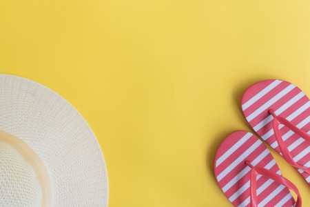 Summer hat and flip flops on a yellow background. Top view, flat layの写真素材