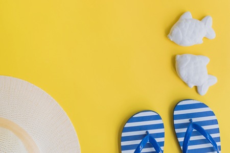 Summer hat and flip flops on a yellow background. Top view, flat layの写真素材