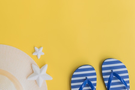 Summer hat and flip flops on a yellow background. Top view, flat layの写真素材