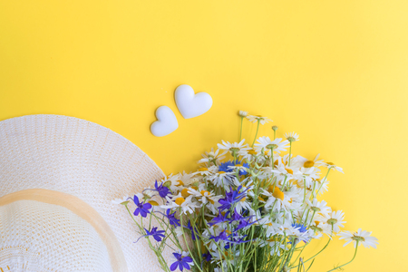 Summer hat and flowers on a yellow background. Top view, flat layの写真素材