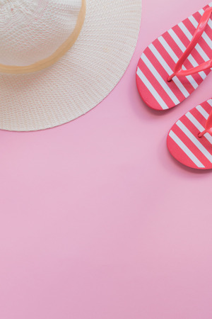 Summer hat and flip flops on a pink background. Top view, flat layの写真素材