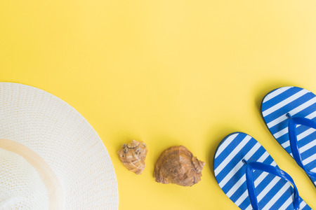 Summer hat and flip flops on a yellow background. Top view, flat layの写真素材