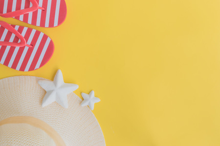 Summer hat and flip flops on a yellow background. Top view, flat layの写真素材