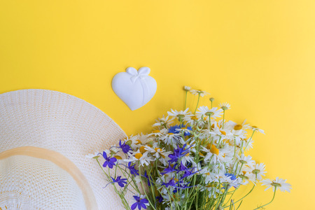 Summer hat and flowers on a yellow background. Top view, flat layの写真素材