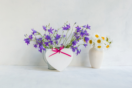 Home interior and garden concept with summer flowers in a metal bucket on a light backgroundの写真素材
