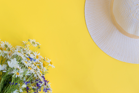 Summer hat and flowers on a yellow background. Top view, flat layの写真素材