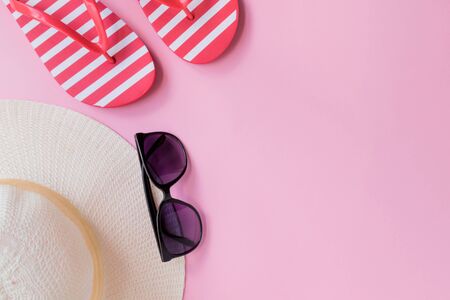 Summer hat, flip flops and sunglasses on a pink background. Top view, flat layの写真素材
