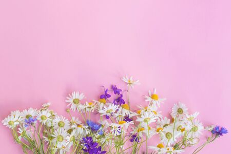 Bouquet of summer flowers on a pink background. Top view, flat layの写真素材