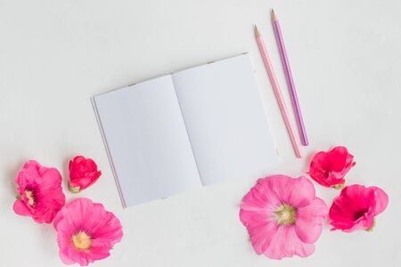 Mockup notebook with pink flowers on a light background empty space for your text, top viewの写真素材