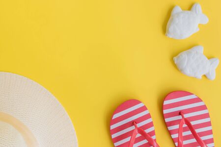 Summer hat and flip flops on a yellow background. Top view, flat layの写真素材