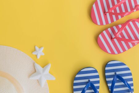 Summer hat and flip flops on a yellow background. Top view, flat layの写真素材