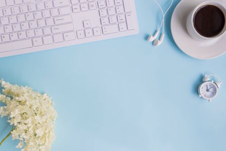 Blogger or freelancer workspace with white flower hydrangea on blue backgroundの写真素材