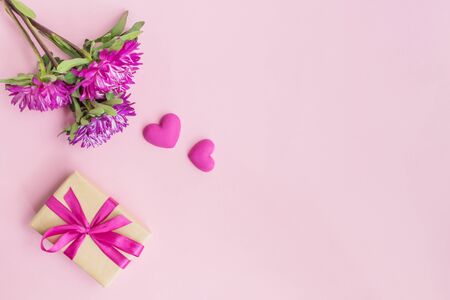 Pink flowers and red hearts, gift box on a pink backgroundの写真素材