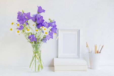 Home interior with decor elements. White frame, flowers in a vase, interior decorationの写真素材