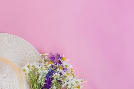 Summer hat and flowers on a pink background. Top view, flat layの写真素材