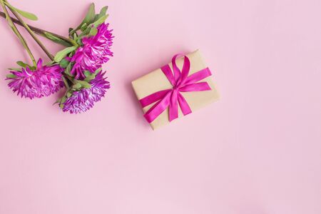 Pink flowers and gift box on a pink backgroundの写真素材