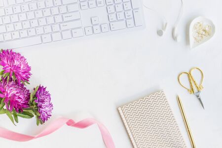 Blogger or freelancer workspace with notebook and pink flowers on light backgroundの写真素材