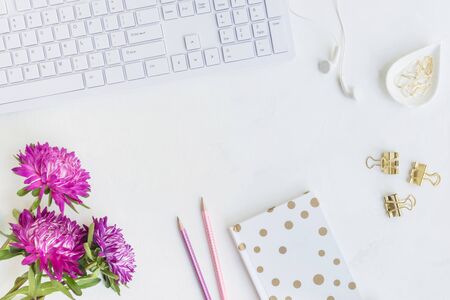 Blogger or freelancer workspace with notebook and pink flowers on light backgroundの写真素材