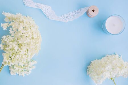 Flat lay desk with white flower hydrangea and accessories on blue backgroundの写真素材