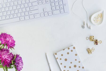 Blogger or freelancer workspace with notebook and pink flowers on light backgroundの写真素材