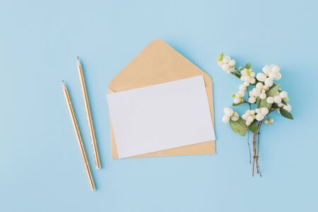 Mockup blank paper card and envelope on a blue background. Flat lay, top viewの写真素材